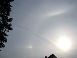 De 22&deg;-Halo, tosamen mit  en Arm vun'n Ber&uuml;hrungsbagen un en Nevens&uuml;nn. Opnahm vun B.K&uuml;hne